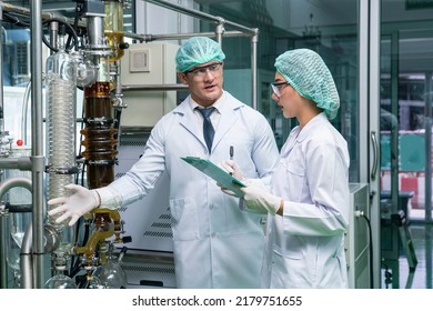  female researcher and a male scientist are uniformed in the lab to extract cannabis flowers for medicinal and medicinal extracts. CBD produces controlled oil in the lab. - Shutterstock ID 2179751655