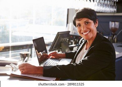 Female Restaurant Manager Working At Counter