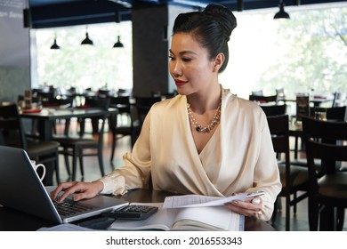 Female Restaurant Owner Checking Reports With Financial Data And Preparing Documents For Tax Department