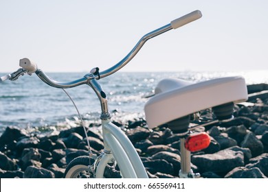 Female retro bicycle on the beach on a background of blue sea on a sunny day, close-up - Powered by Shutterstock