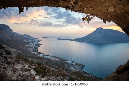 Female rock climber against picturesque view of Telendos Island at sunset. Kalymnos Island, Greece. 