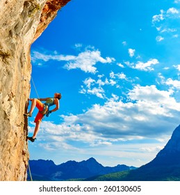 Female Rock Climber Climbs On A Rocky Wall