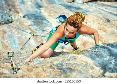 Female Rock Climber Climbs On A Rocky Wall