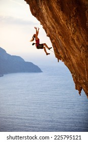 Female rock climber falling of a cliff while lead climbing 