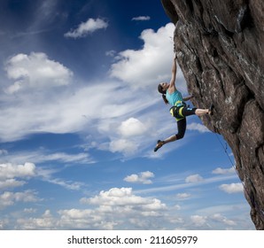 Female Rock Climber Hanging Over The Abyss