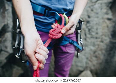 Female rock climber prepares equipment for climbing, a woman holds a rope in her hands, a climber ties a knot - Powered by Shutterstock