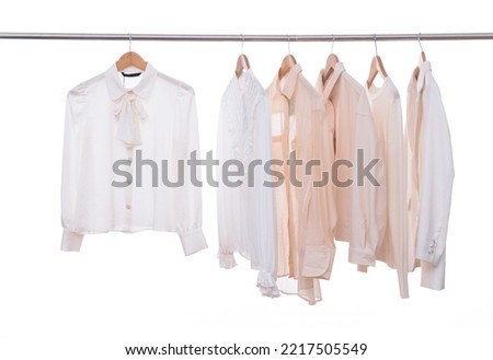 female row of suit,blouses ,white shirt  on hanger