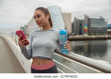 Female Runner Chatting On Mobile Phone While Relaxing After Active Fitness Training Outside