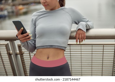 Female Runner Chatting On Mobile Phone While Relaxing After Active Fitness Training Outside