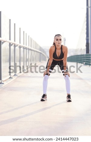 Female runner having break during city workout
