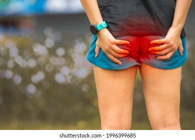 A Female Runner Hurts Her Butt While Running In The Park. Stomach Ache, Sore While Jogging.The Pain Caused By Hemorrhoid Concept.