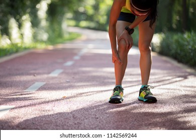 Female runner suffering with pain on sports running knee injury  - Shutterstock ID 1142569244