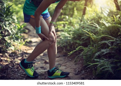 Female Runner Suffering With Pain On Sports Running Knee Injury 