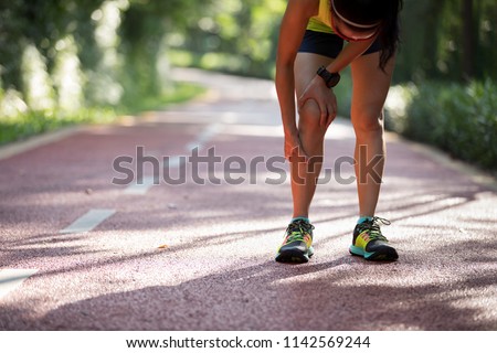 Female runner suffering with pain on sports running knee injury 
