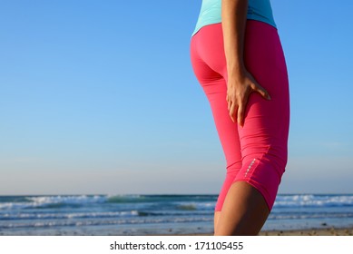 Female Runner Suffering From A Painful Hamstring Muscle Contracture Or Spasm During Training. Sport Leg Injury During Running Concept.