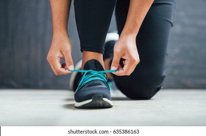 Female runner tying her shoes preparing for a run