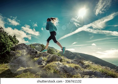 Female running in mountains under sunlight. - Powered by Shutterstock