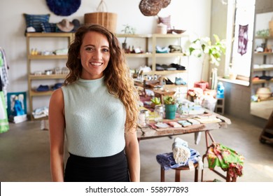 Female Sales Assistant Standing In Clothes Shop, Portrait