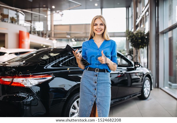 Female sales person in a\
car showroom