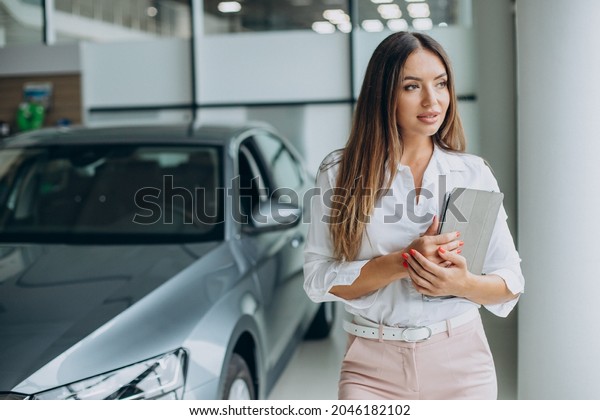 Female sales person at a\
car showroom