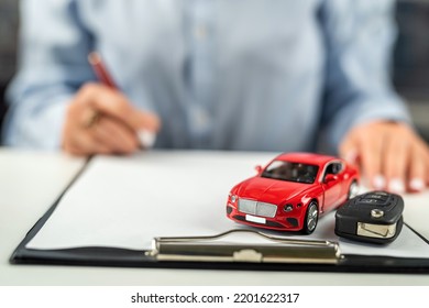 Female Sales Representative Used Two Hand-held Small Model Cars. An Employee Of A Car Rental Company. Ideas For Renting And Buying A Car With Insurance