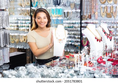 Female Salesperson Demonstrates Gemstone Necklace In Jewelry Store