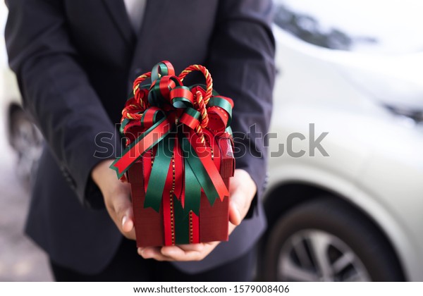 Female salesperson give gifts to customers. Buy\
a new car at the\
showroom.
