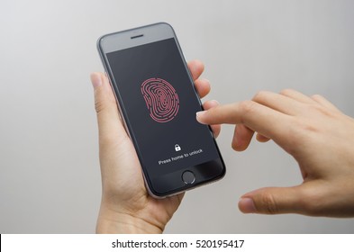 Female Scanning Fingerprint On Smartphone, On Gray Background. Unlock Mobile Phone.