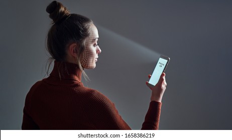 Female scans face using facial recognition system on smartphone for biometric identification. Future high tech technology and face id