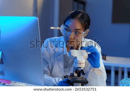 Female scientist analyzing microscope data, conducting advanced biomedical research in sterile laboratory environment