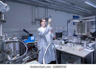 Female Scientist Examining Microscopy Slide In Lab