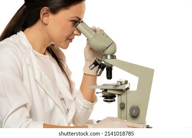 Female Scientist Looking Through A Microscope, White Background. Side View