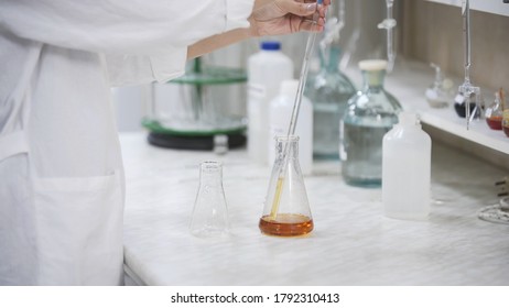 Female scientist with pipette analyzes liquid in distillery laboratory researcher. Analysis of whiskey sample on laboratory equipment. - Powered by Shutterstock