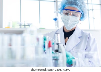 Female scientist testing experiment in a science lab where there are chemical substances and equipment. The researcher is analyzing the medicine related innovation. Bio chemistry concept. Copy space.