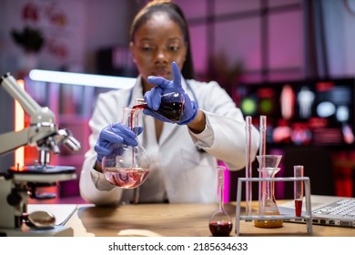 Female Scientist Testing Experiment In A Science Lab Where She Holding Scientific Test Tube Full Of Chemical Substance. The Researcher Is Analyzing Medicine Related Innovation. Microbiology Concept.