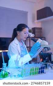 Female scientist using a microscope to analyze samples.