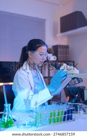 Female scientist using a microscope to analyze samples.