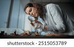 Female scientist works with specimen collection of fossil remains in archaeological laboratory. Archaeologist or paleontologist studies bones of ancient extinct human skeleton with magnifying glass.