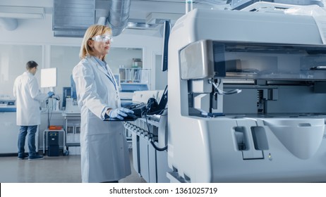 Female Scientists Programs Medical Equipment with Personal Computer. Team Of Professionals Working in Pharmaceutical Research Modern Laboratory.