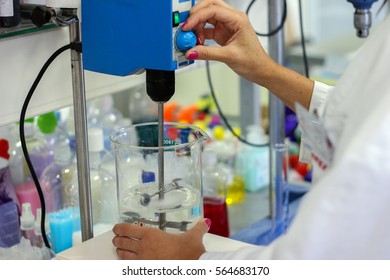 Female Scientists Working in Laboratory. Mixing Solution in Glass Beaker with Laboratory Mixer. Engineer Mixing Chemical in Laboratory. Laboratory Stirrer/Mixer. Chemist Working with Lab Mixer.