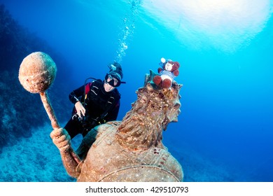 Female SCUBA Diver and a Large Underwater Statue - Powered by Shutterstock