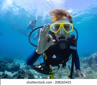 Female scuba diver underwater showing ok signal - Shutterstock ID 208265431
