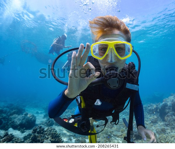 Female scuba\
diver underwater showing ok\
signal