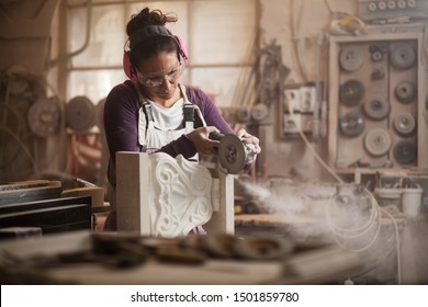 Female Sculptor Cutting A White Marble Piece With A Power Tool, Craftswoman Shaping A Sculpture With An Angle Grinder, Caucasian Woman Working Inside An Arts Workshop, Dust And Debris Flying Away 