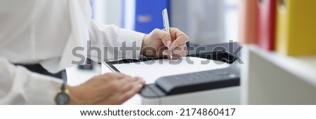 Female secretary or office worker print papers on printer machine