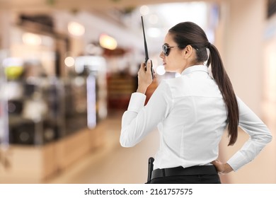 Female Security Guard Using Portable Radio Transmitter In Mall