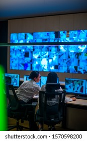 Female Security Guards Working In Surveillance Room, Monitoring Cctv And Discussing.