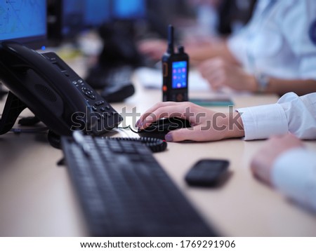 Female security operator working in a data system control room offices Technical Operator Working at  workstation with multiple displays, security guard working on multiple monitors