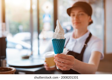 A Female Seller Holds A Cone With A Twisted Ice Cream From A Vending Machine In Her Hand. Small Business And Takeaway Food, Summer Food, Cool Off In The Heat