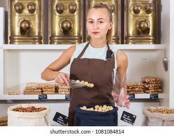 Female is selling Macadamia and on the plate is written in Catalan in the food store. - Shutterstock ID 1081084814